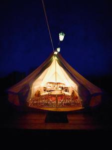 Zelt mit einem Tisch und einer Lampe oben in der Unterkunft Gårdshotellets Camping in Ystad