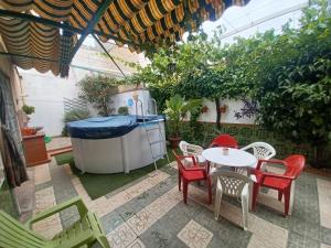 patio con mesa, sillas y bañera de hidromasaje en El Rincón de la Rosa, en La Zubia