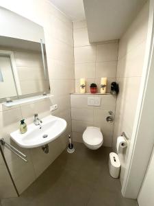 a white bathroom with a toilet and a sink at Haus Maria Isenburg - Naturpark Rhein-Westerwald in Isenburg