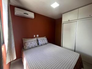 Dormitorio pequeño con cama y aire acondicionado en Studio Design - apto com varanda e lazer completo na Ponta Verde, en Maceió