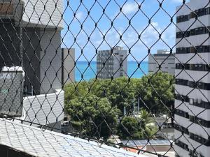 - Vistas a la ciudad a través de una valla de cadena en Studio Design - apto com varanda e lazer completo na Ponta Verde, en Maceió