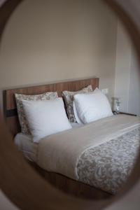 lustro z łóżkiem z białymi poduszkami w obiekcie Μελίτη Pelion Luxury Living w mieście Zagora