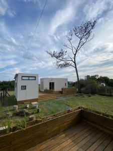 a small house on a deck in a yard at Tiny House Agua en La Juanita in José Ignacio