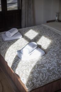 a bed with two towels on top of it at Μελίτη Pelion Luxury Living in Zagora