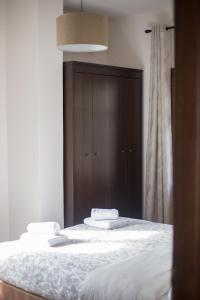 a bedroom with two beds and a brown cabinet at Μελίτη Pelion Luxury Living in Zagora