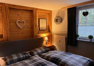 um quarto com duas camas e um coração na parede em Hexenstuben Tanne - 4 DTV Sterne em Tanne