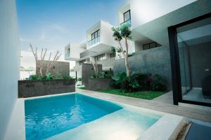 a swimming pool in front of a building at Saria 7C Temozón in Mérida