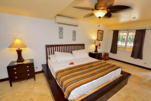 um quarto com uma cama e uma ventoinha de tecto em Caribbean Shores Belize em Hopkins