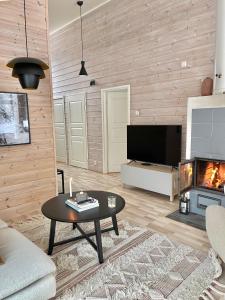 sala de estar con mesa y chimenea en Villa Laidike with sauna/fireplace, 80 km Helsinki, en Suomusjärvi