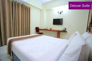 ein Hotelzimmer mit einem Bett und einem Schild mit der Aufschrift "göttliche Suite" in der Unterkunft Royal Beach Resort in Cox's Bazar