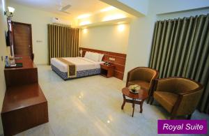 a hotel room with a bed and a chair at Royal Beach Resort in Cox's Bazar