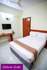 een slaapkamer met een groot bed en een televisie bij Royal Beach Resort in Cox's Bazar