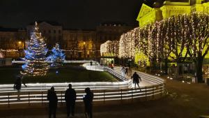 a group of people walking around a courtyard with christmas lights at KUHARIĆ in Zagreb