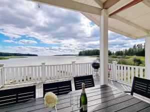 a porch with two chairs and a bottle of wine at Holiday home SÄFFLE IV in Säffle