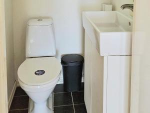 een badkamer met een toilet, een wastafel en een vuilnisbak bij Holiday home SÄFFLE IV in Säffle