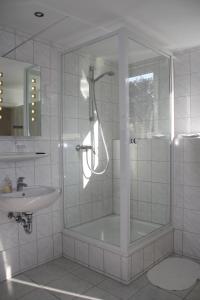 a bathroom with a shower and a sink at Hotel Anchovis in Mönchengladbach