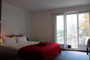 a bedroom with a large bed with a red blanket at The Engstligen in Adelboden