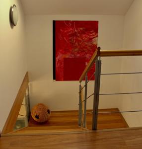 a painting hanging on a wall next to a stairway at Private holiday house Vivendi in Liptovský Mikuláš