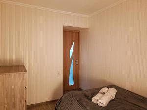 - une chambre avec un lit et des serviettes dans l'établissement Apartment LINIMA, à Tbilissi