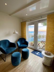 een woonkamer met 2 stoelen en uitzicht op de oceaan bij Ahoi Husum, anlegen und wohlfühlen in Husum