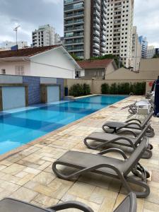 - une rangée de chaises longues à côté de la piscine dans l'établissement Flat na Vila Olimpia rua Santa Justina, à São Paulo