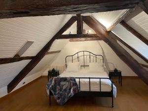 1 dormitorio con 1 cama en el ático en La Bureliere- Holiday home for families, groups and couples, en Gorron