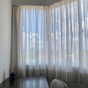 Habitación con ventana grande con cortinas blancas. en Ap aconchegante e climatizado ótima localização, en Foz do Iguaçu