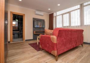 Una sala de estar con un sofá rojo y un televisor. en 216 Hill Suites, en Estambul