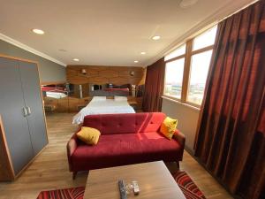 una camera con un letto e un divano rosso di HİLL SUİTES a Istanbul