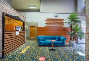 a lobby with a blue couch and a palm tree at HİLL SUİTES in Istanbul