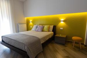 - une chambre dotée d'un lit avec un mur jaune dans l'établissement Casa Martina, à Castellammare di Stabia