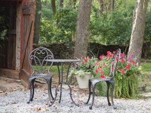 twee stoelen en een tafel met bloemen in de tuin bij Inn at Glencairn in Princeton