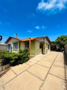 a small green house with a sidewalk in front of it at Cabaña Algarrobo in Algarrobo