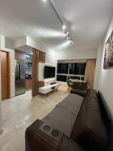 a living room with a large couch and a kitchen at Recanto do Bosque FLAT 205 in Caldas Novas