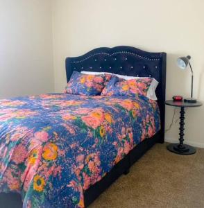 a bed with a colorful comforter and a table with a lamp at 17 S First - Unit 6 17 s first street unit 6 in Trenton