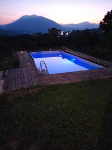 a swimming pool at night with the mountains in the background at Villa Malibu ' in Lauria
