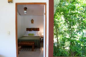 Zimmer mit einem Bett und einer Tür zum Schlafzimmer in der Unterkunft Osa de Rio in Uvita