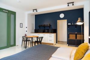 a bedroom with a blue wall and a table and chairs at Design Studio Altstadt nahe Malerweg in Pirna