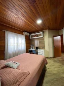 1 dormitorio con 1 cama con techo de madera en Casa Brisa do Mar: Piscina e Conforto - Penha, en Penha