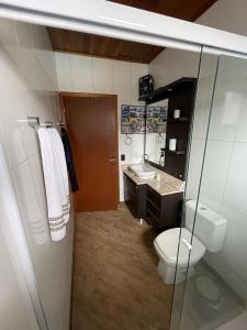 y baño con aseo, lavabo y espejo. en Casa Brisa do Mar: Piscina e Conforto - Penha, en Penha