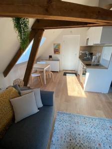 een woonkamer met een bank en een keuken bij Chez Mathilde Studio Calais Nord Citadelle in Calais