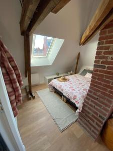 Zimmer im Dachgeschoss mit einem Bett und einem Fenster in der Unterkunft Chez Mathilde Studio Calais Nord Citadelle in Calais