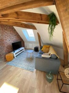 a living room with a couch and a tv at Chez Mathilde Studio Calais Nord Citadelle in Calais