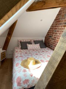 a bedroom with a bed with a hat on it at Chez Mathilde Studio Calais Nord Citadelle in Calais