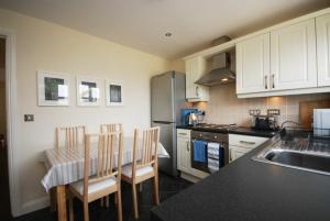a kitchen with a table and chairs and a sink at House Martins Beadnell in Beadnell +3 photos