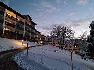 una calle cubierta de nieve frente a un edificio en Ferienwohnung Missen-Wilhams en Missen-Wilhams