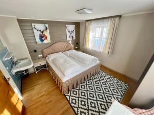 una piccola stanza con un letto e una finestra di Lech Hostel a Lech am Arlberg