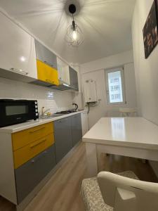 cocina con encimera blanca y armarios amarillos en Luxury Q Residence Near Center, en Iaşi
