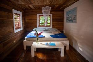 a bedroom with two beds in a log cabin at Dolphin Blue Paradise in Bocas del Toro