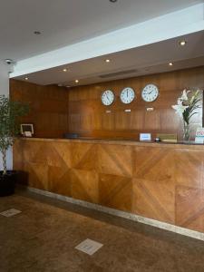 a lobby with three clocks on the wall at Nawaress Hotel in Jazan